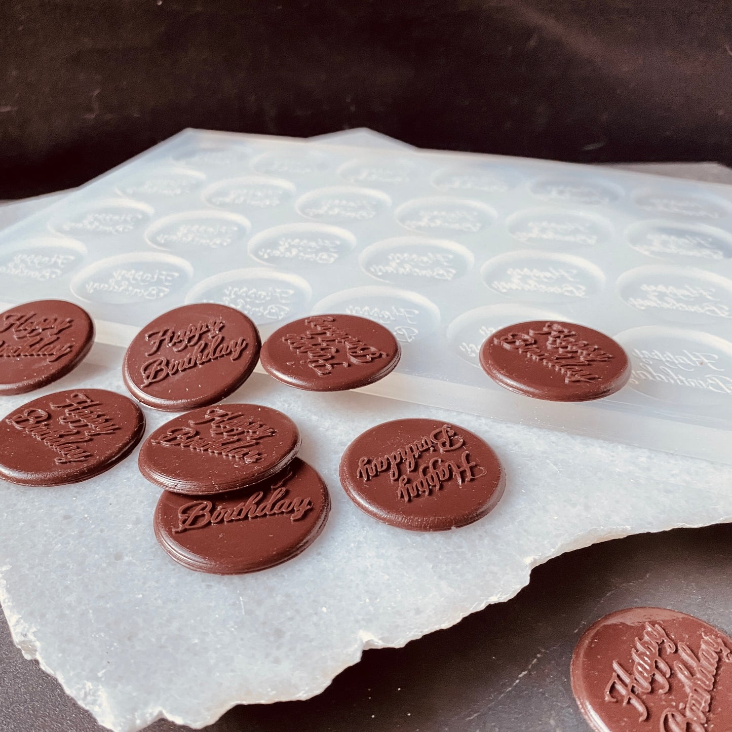 Round silicone mold for butter, wax melts, and chocolate treats.
Chef using a custom butter mold for culinary creations.
Handmade butter portions displayed on a cutting board.